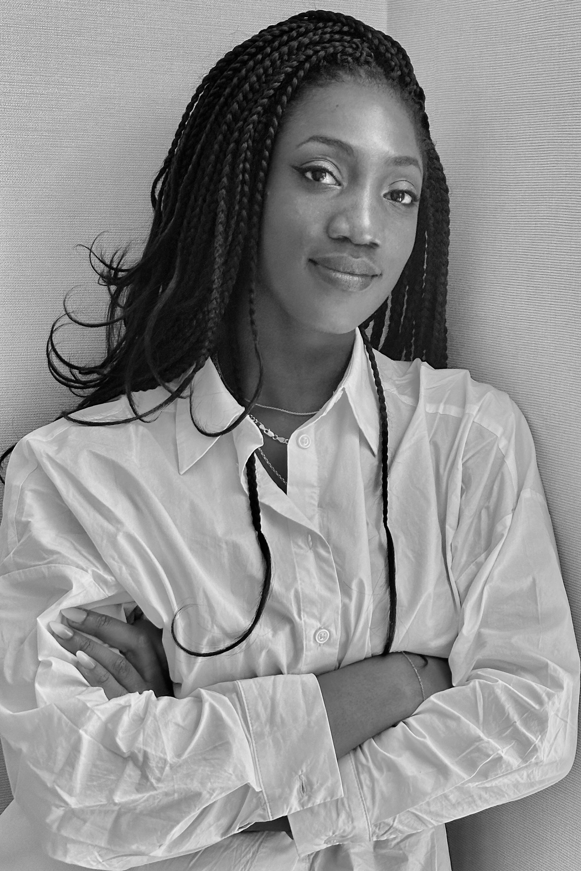 Photo of Johanna wearing a white shirt, arms crossed and smiling.